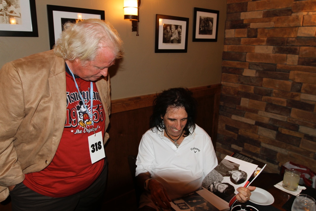 Alice Cooper Looking at photos in Rock & Rowlands Flashback with John